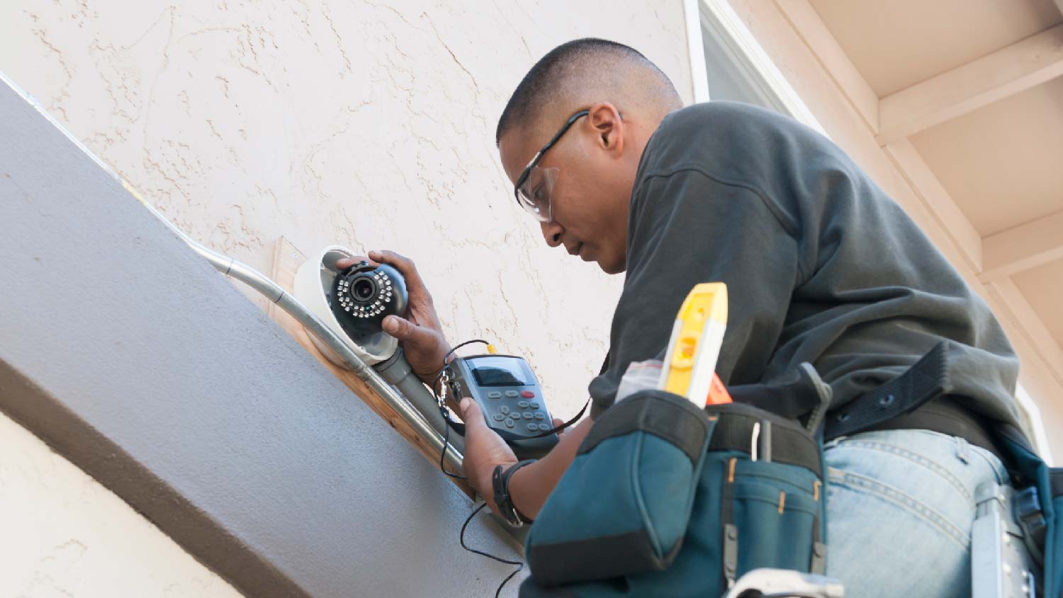 A person installing a security camera