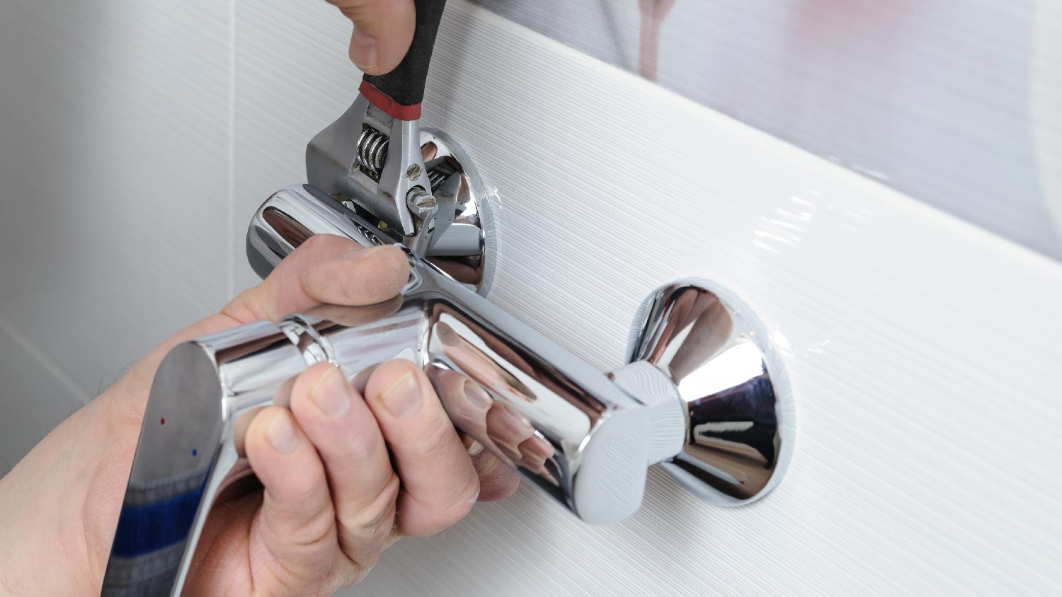 Close-up of a person installing a shower faucet