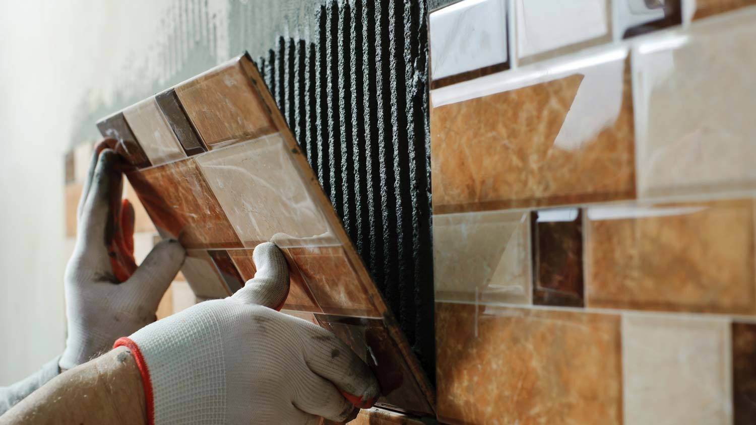 A person installing wall tiles