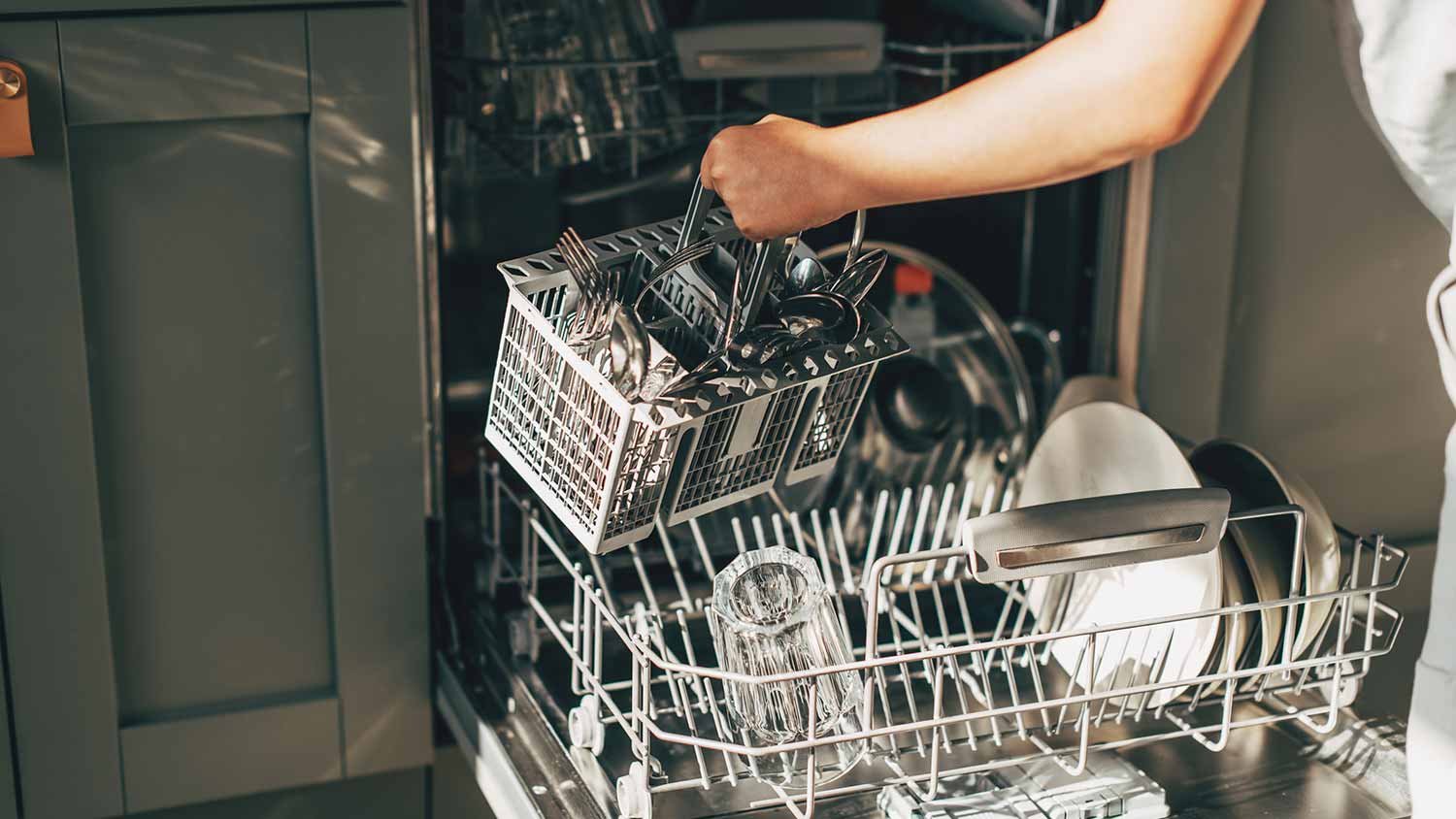 A person loading a dishwasher