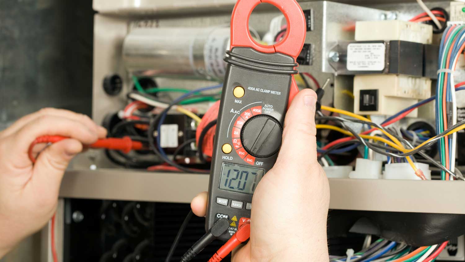 A person measuring the voltage of an appliance using a multimeter