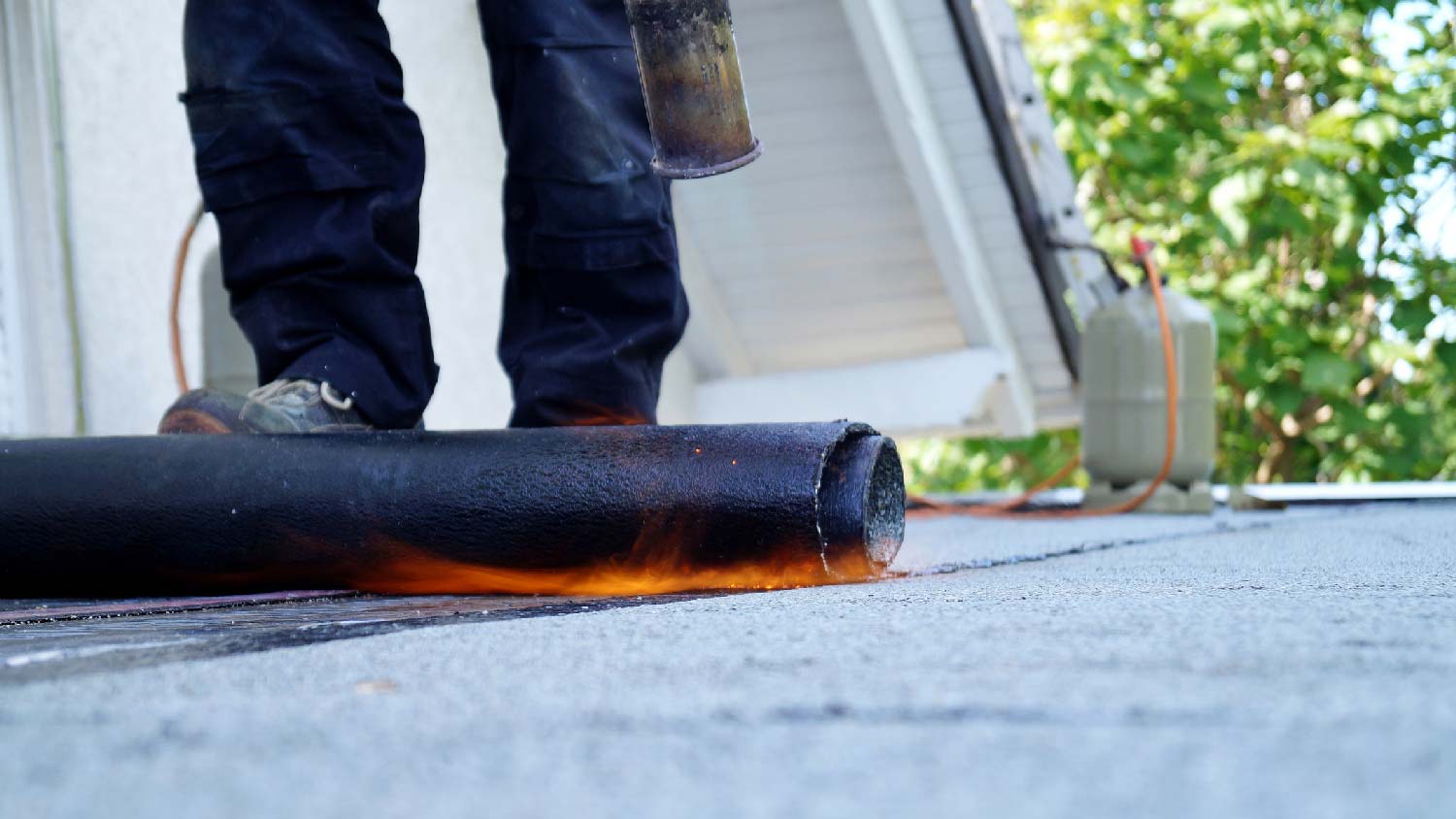 A person melting tar on a flat roof