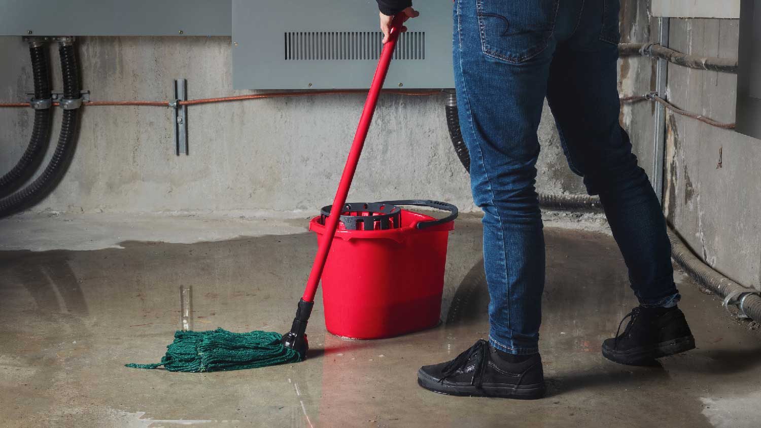 A person moping a flooded basement