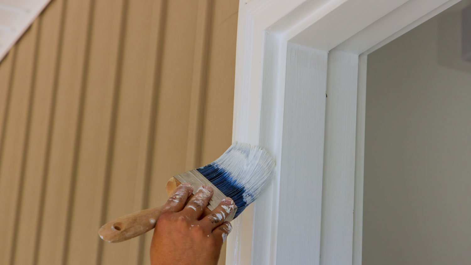 A person painting the door trim