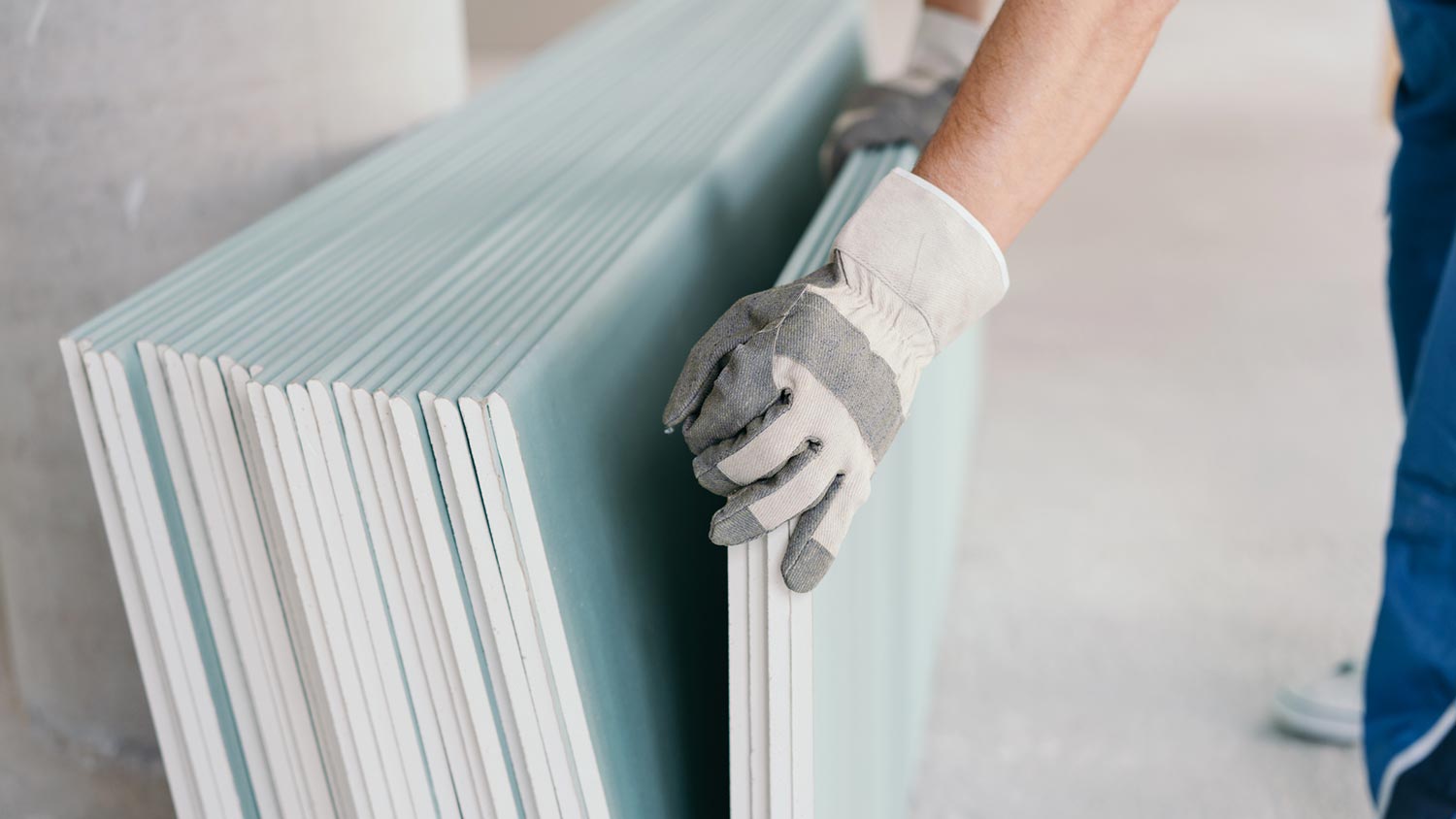 A person picking a drywall sheet