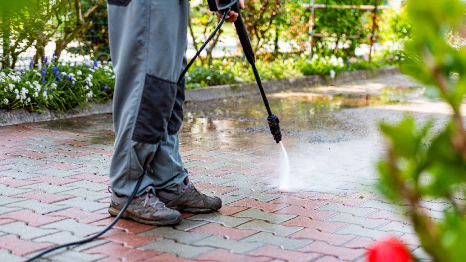 A person power washing a patio