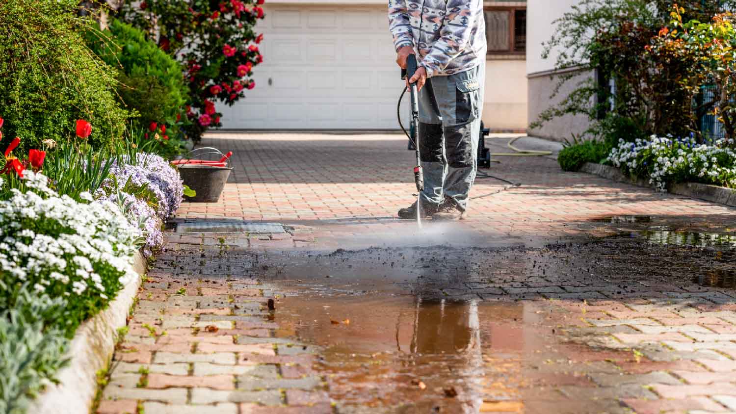 A person pressure washing the driveway