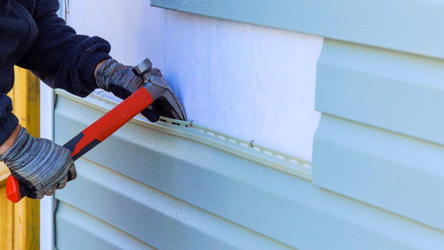 A person removing old siding