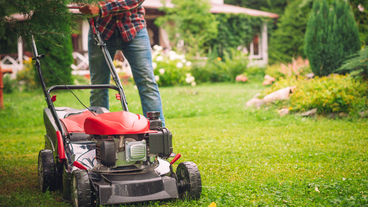 A person using a lawnmower to remove stickers