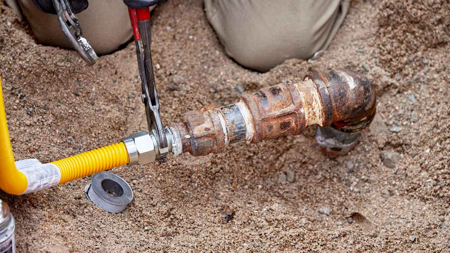 A person repairing a buried gas line 