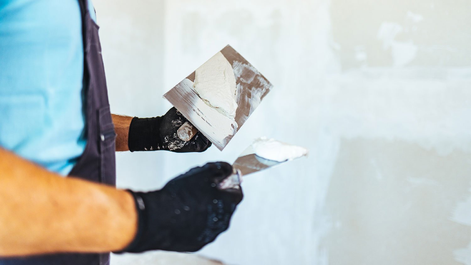 A person repairing a drywall