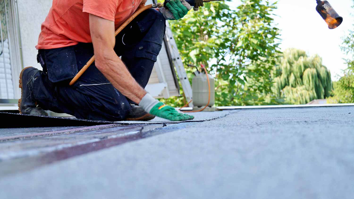 A person repairing the insulation of a flat roof 