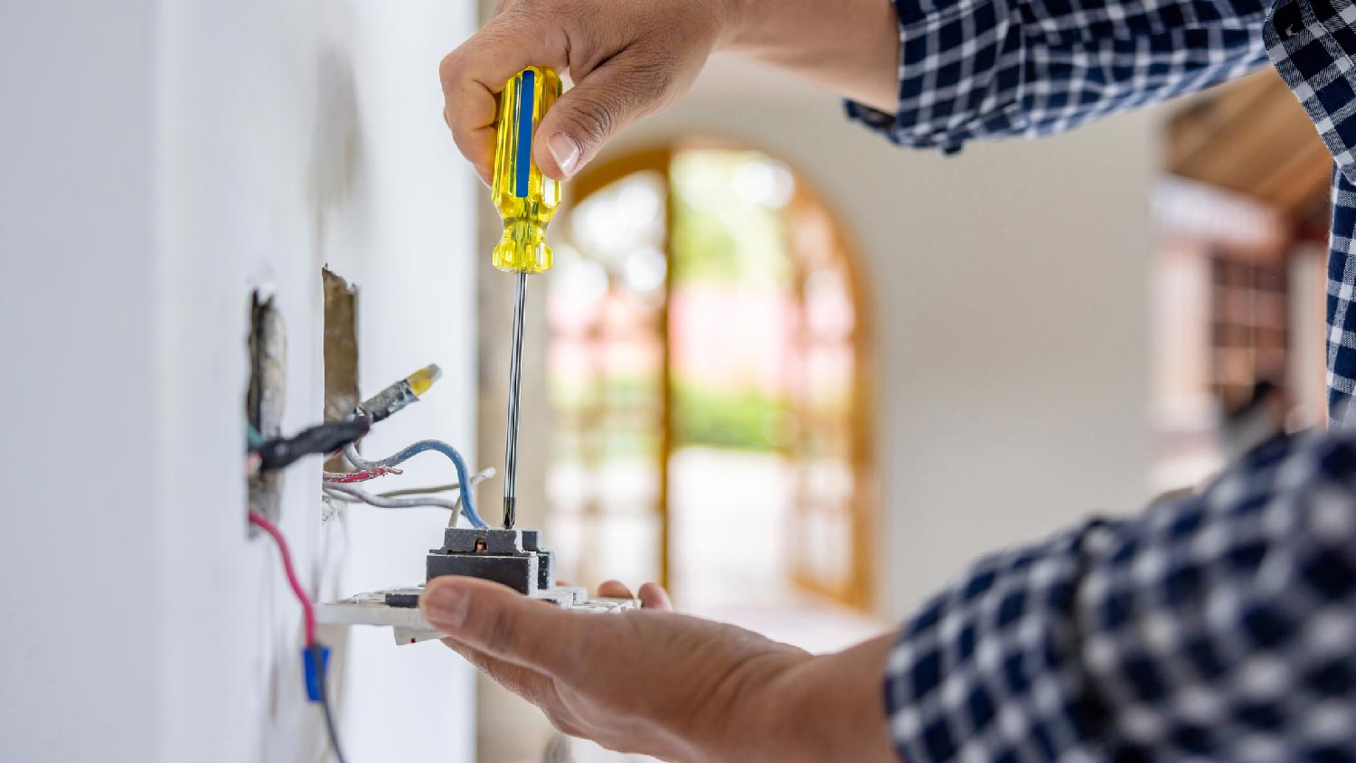 A person repairing an outlet