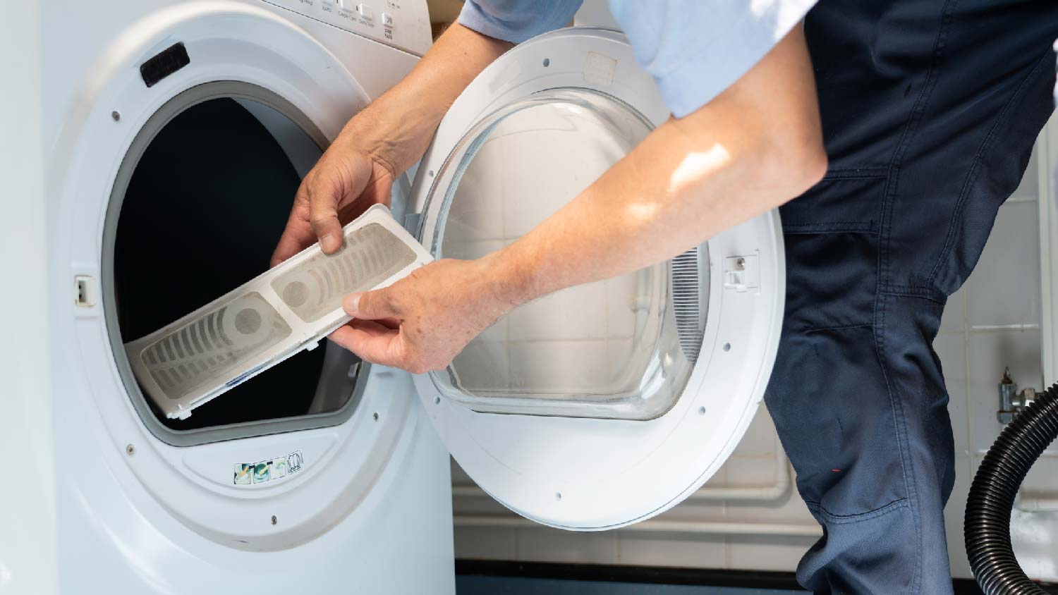 A person replacing a dryer filter