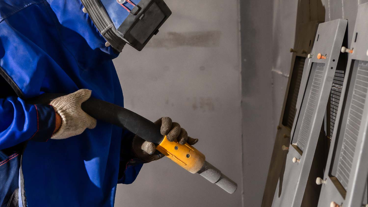 A person sandblasting metal doors