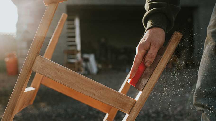 A person sanding a chair