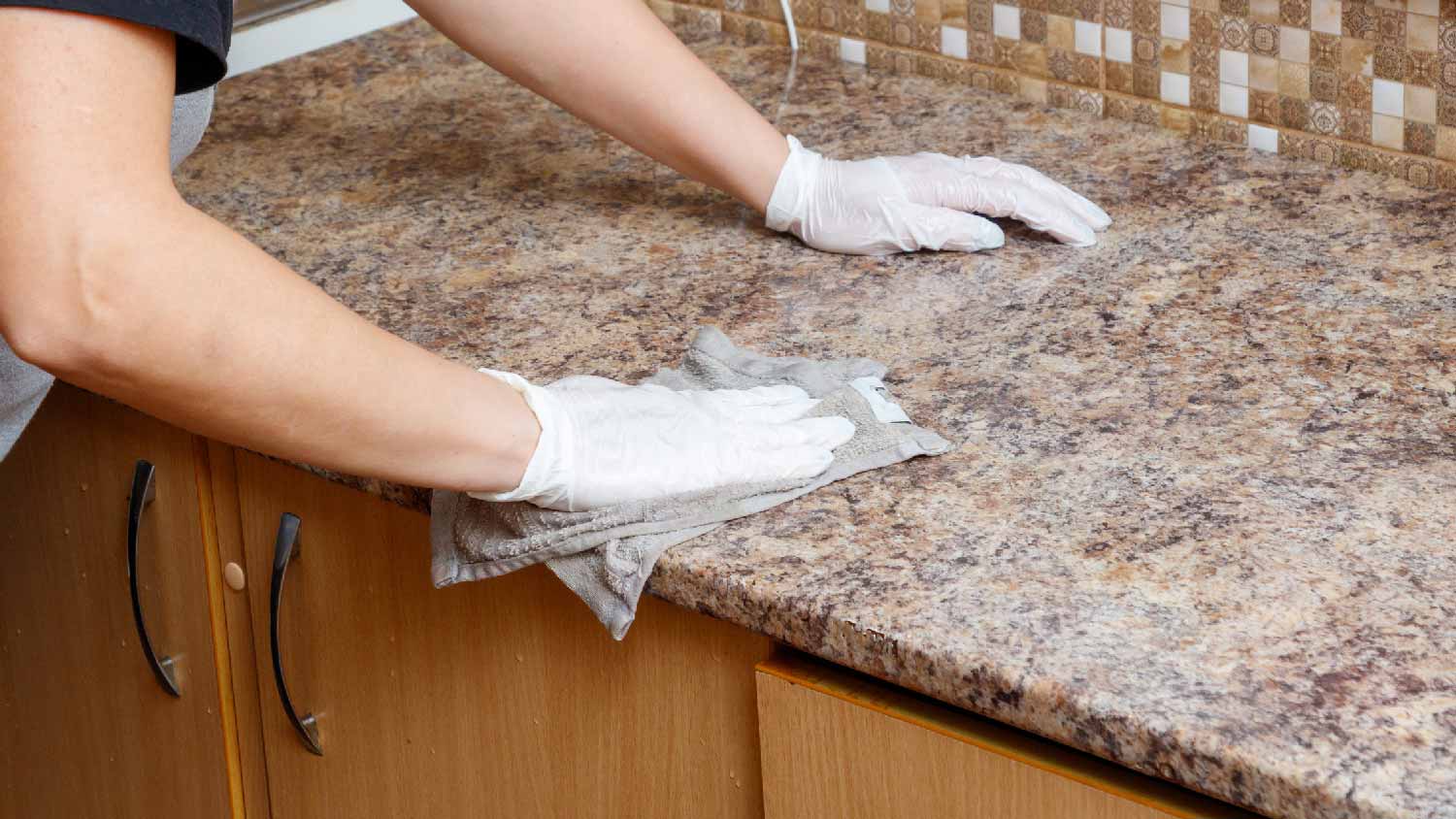 A person sealing a granite countertop 