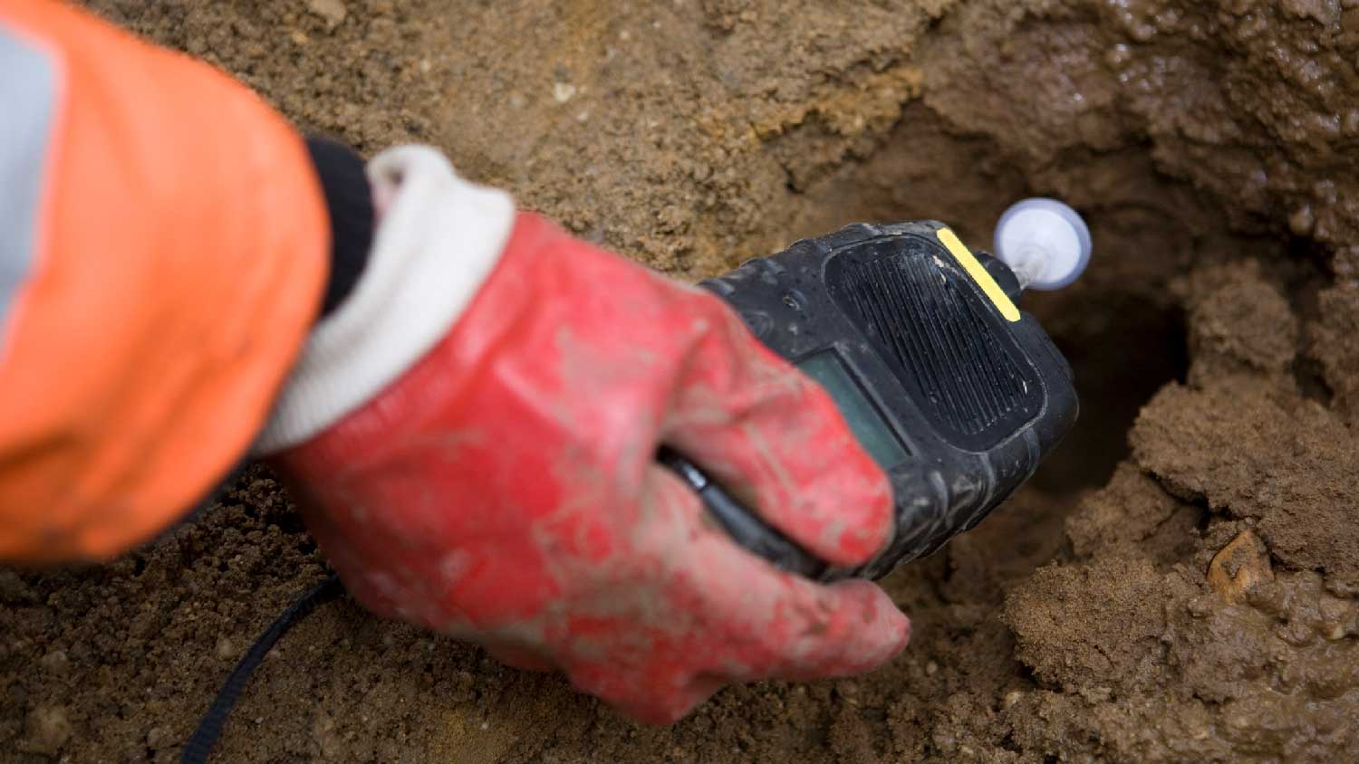 A person taking a soil sample