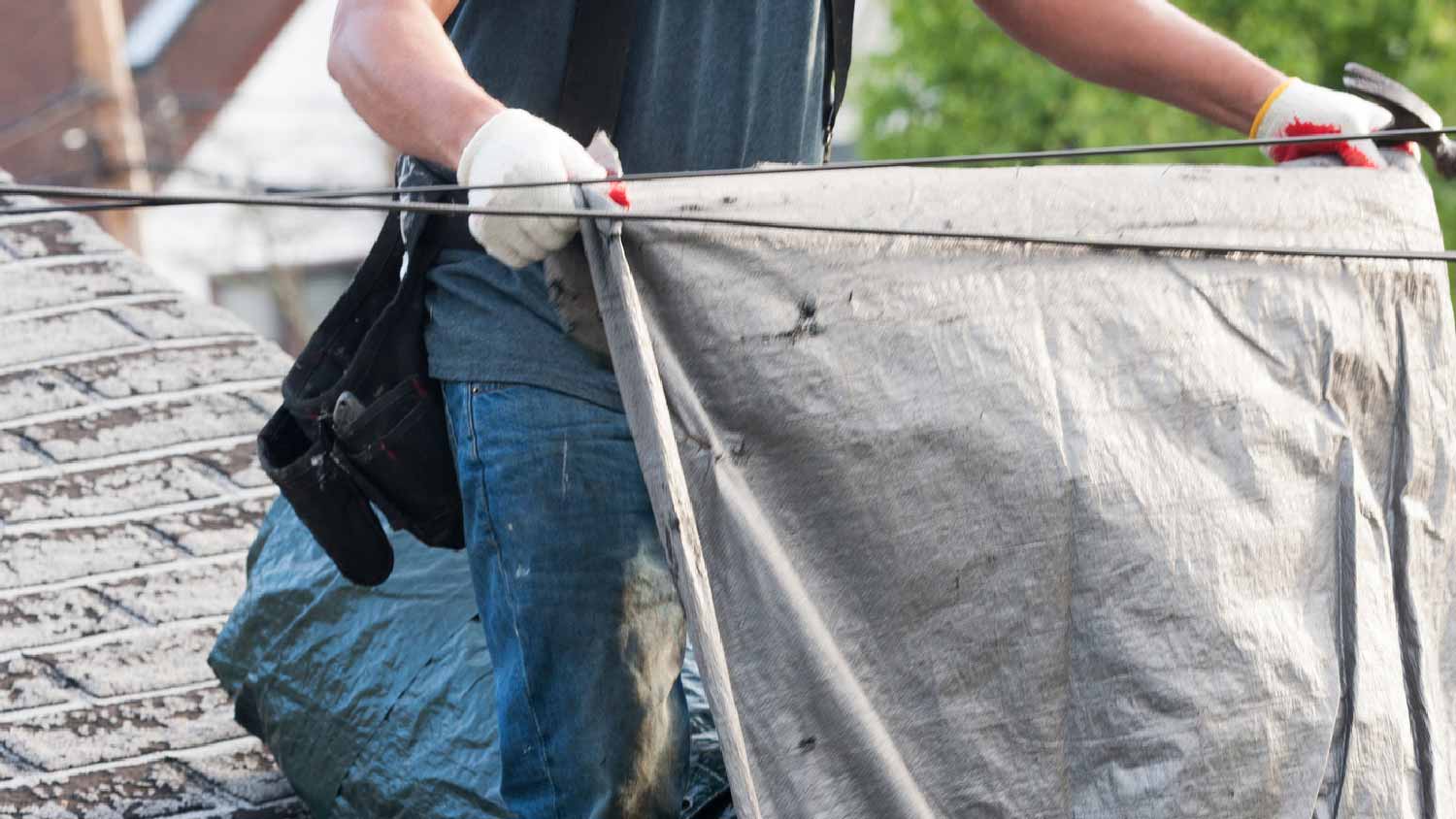 A person tarping a roof