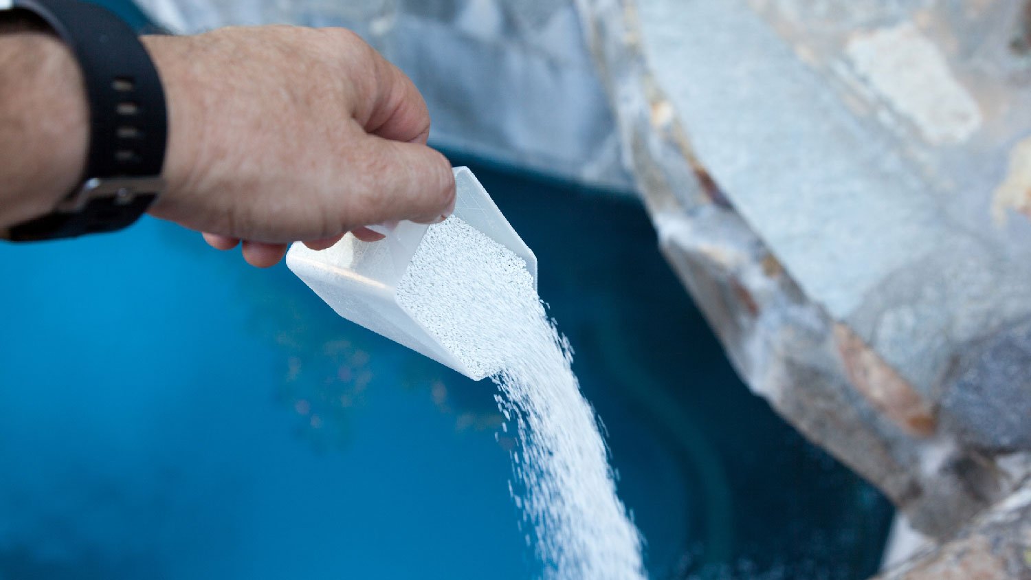 A person throwing chlorine to a pool