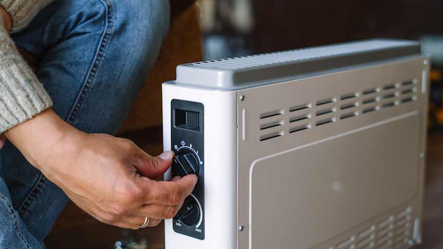 A person turning off a space heater