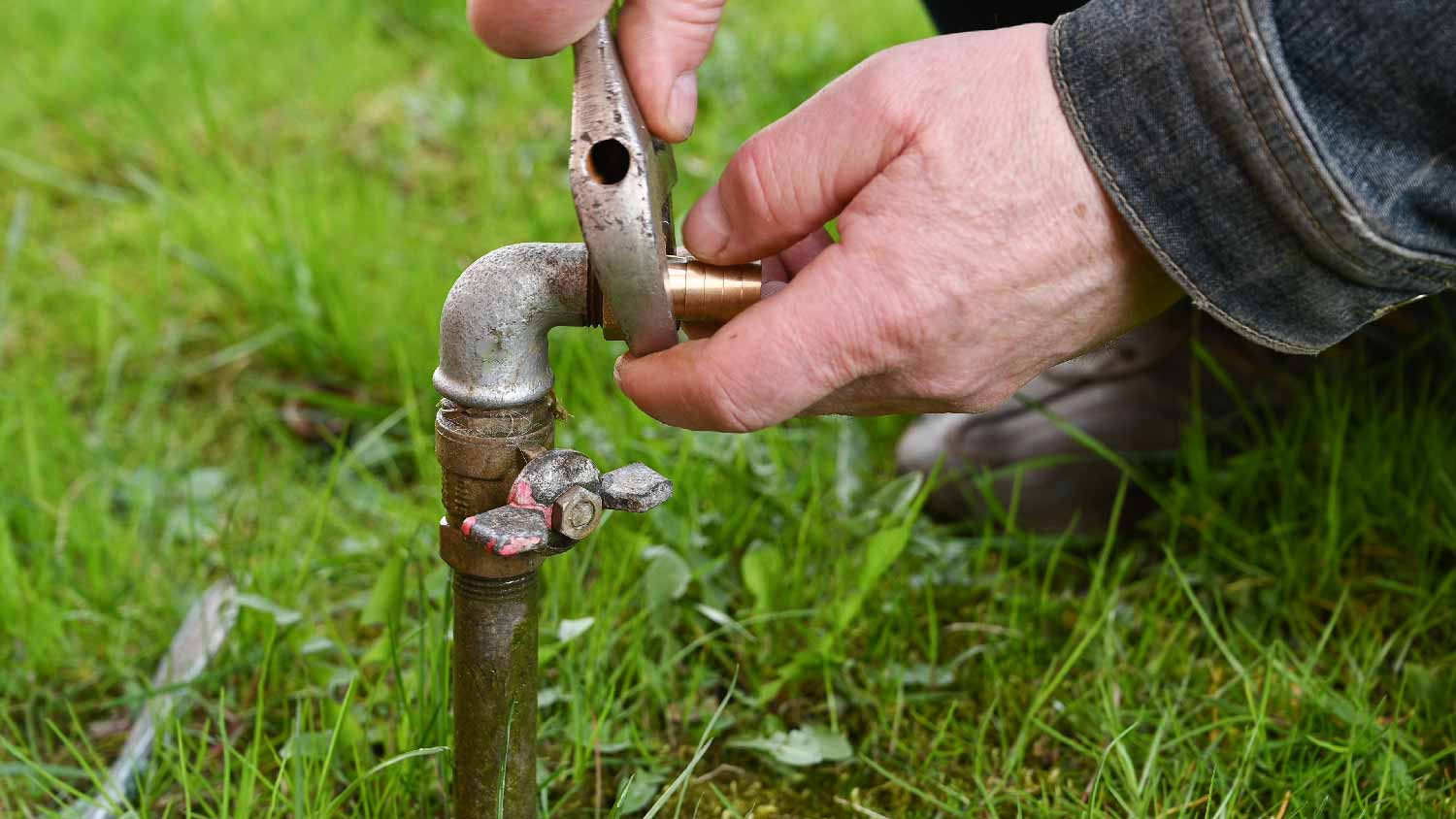 A person turning off a valve