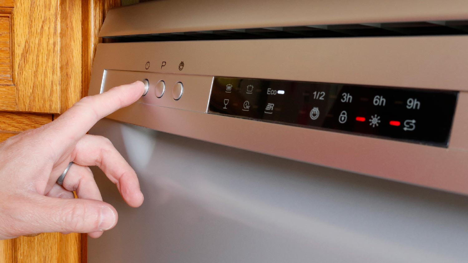 A person turning on a dishwasher