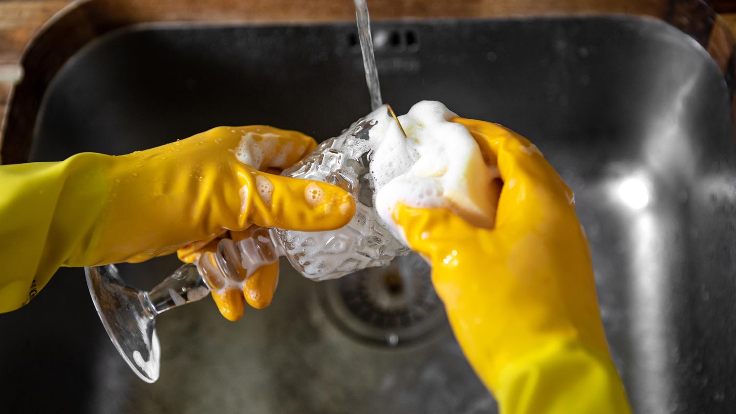 A person washing glassware