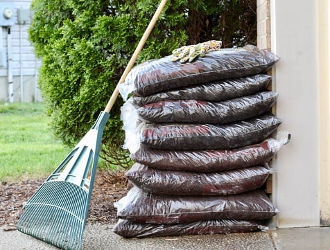 Bags of mulch stacked in the yard
