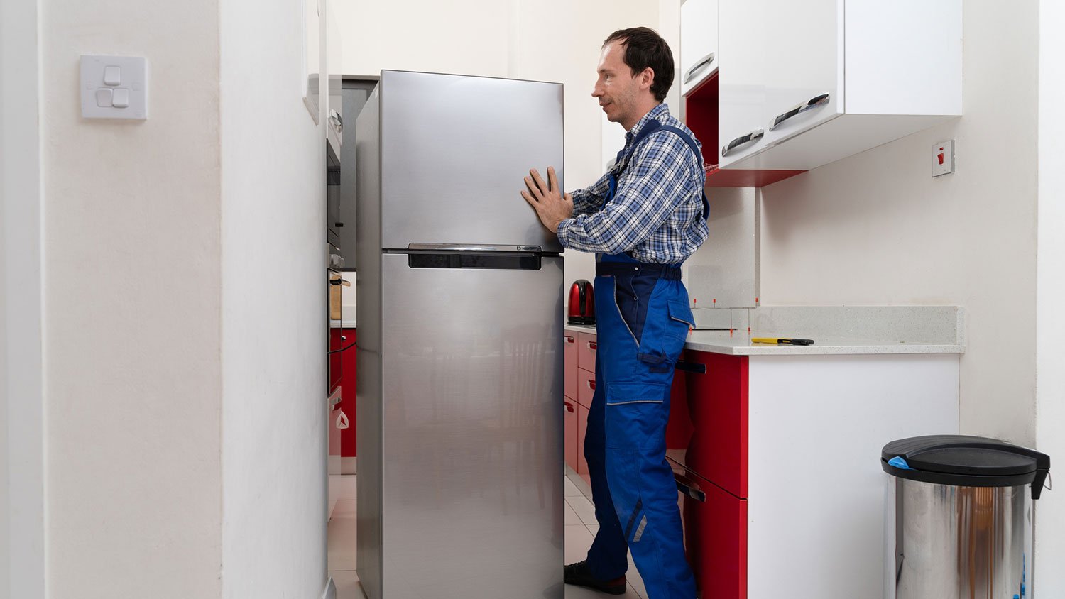 Professional mover placing fridge in the kitchen