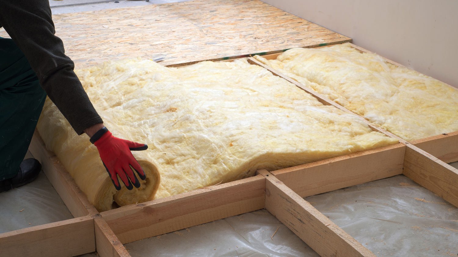 Worker placing mineral wool insulation