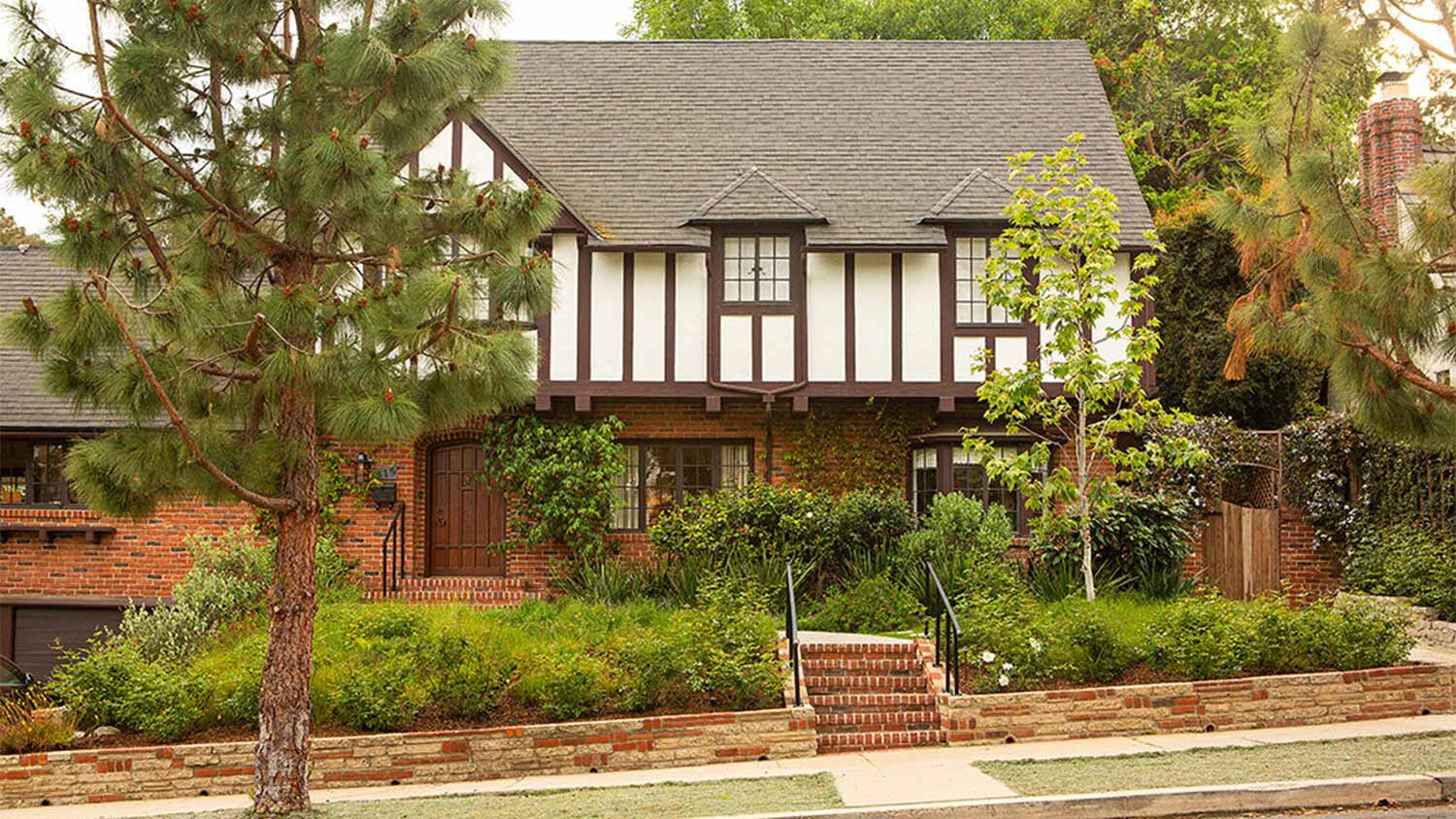 A front lawn with brick garden beds and shrubs