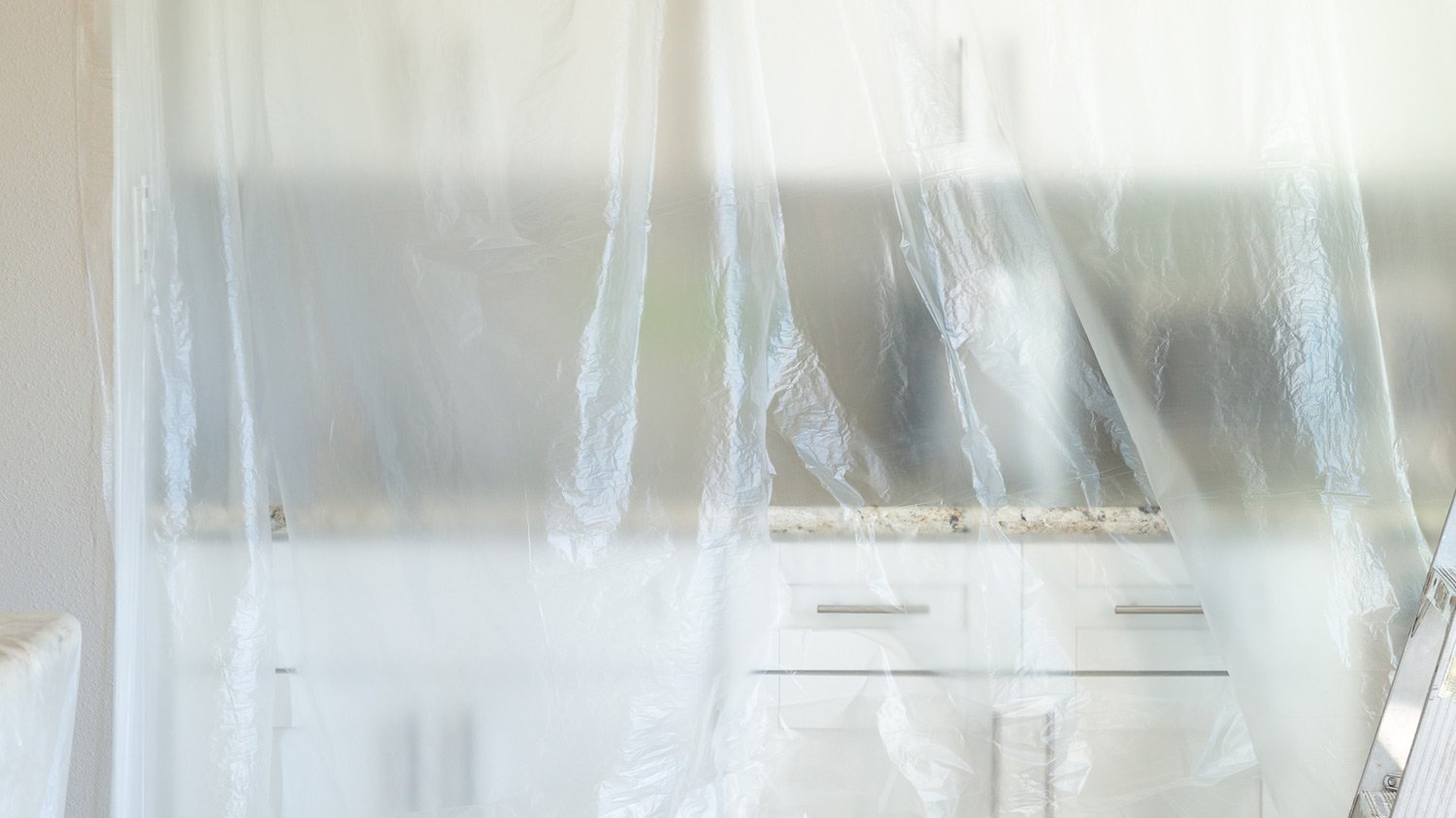 A plastic drop cloth over kitchen cabinets