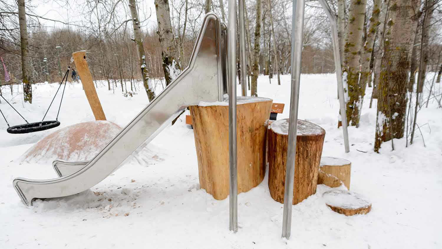 playground made with tree stumps covered with snow