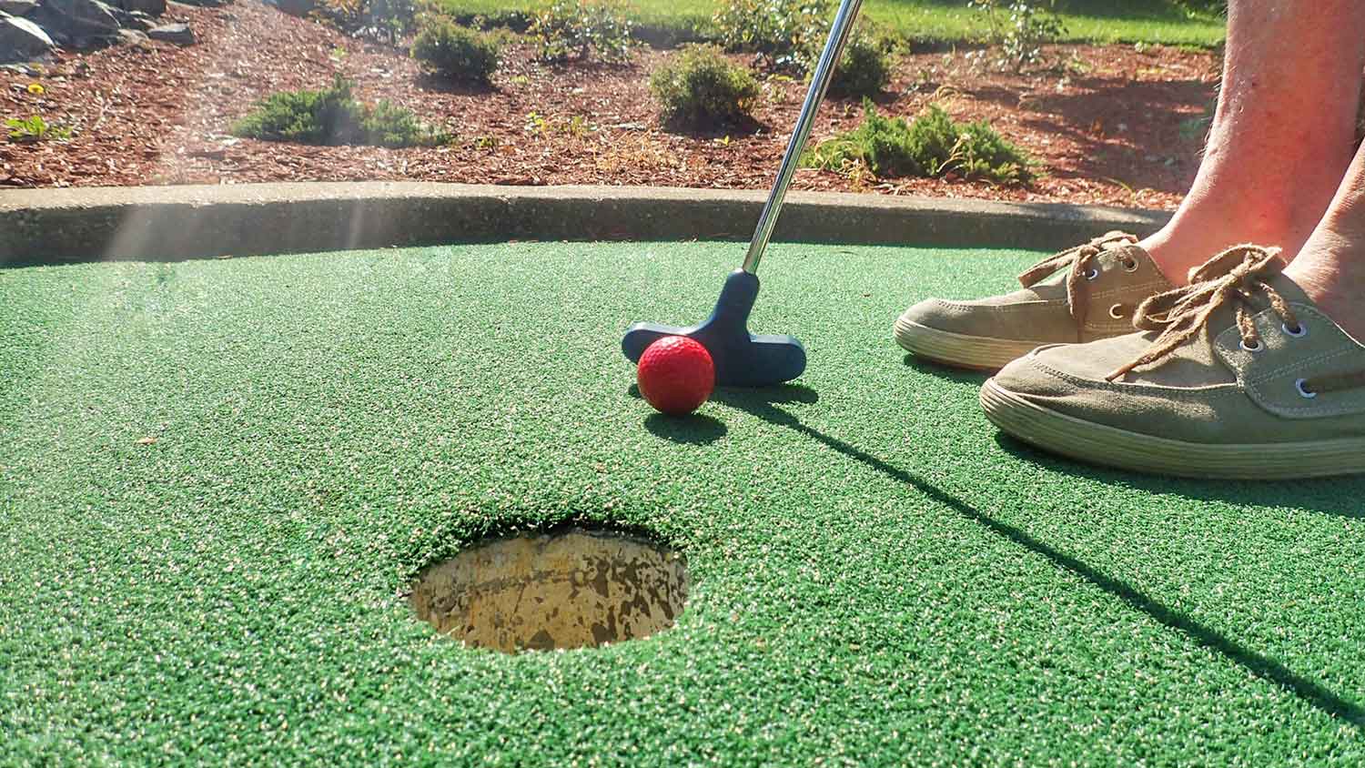 Closeup of a person playing in a mini golf course