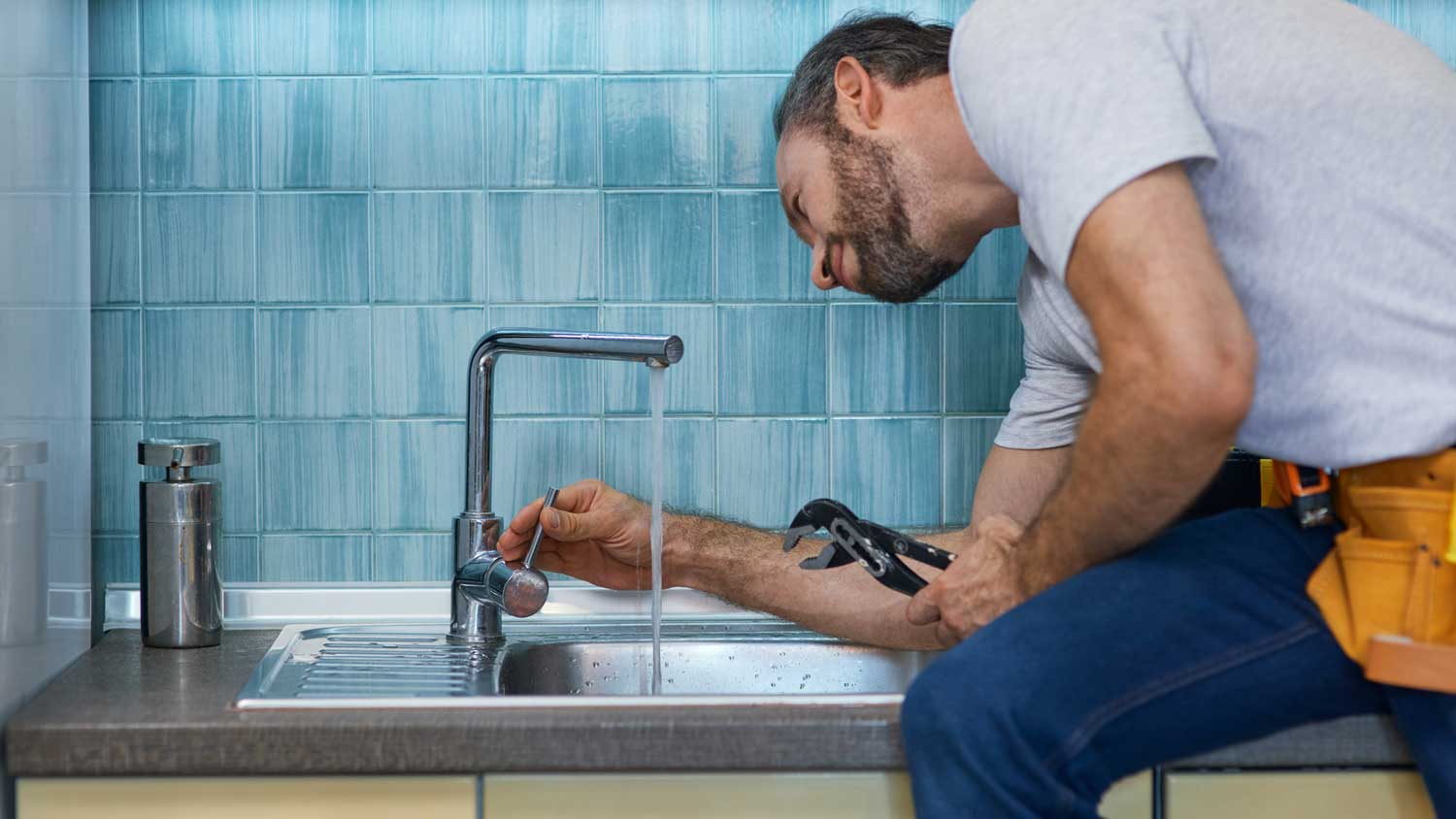 A plumber checking a faucet on a sink