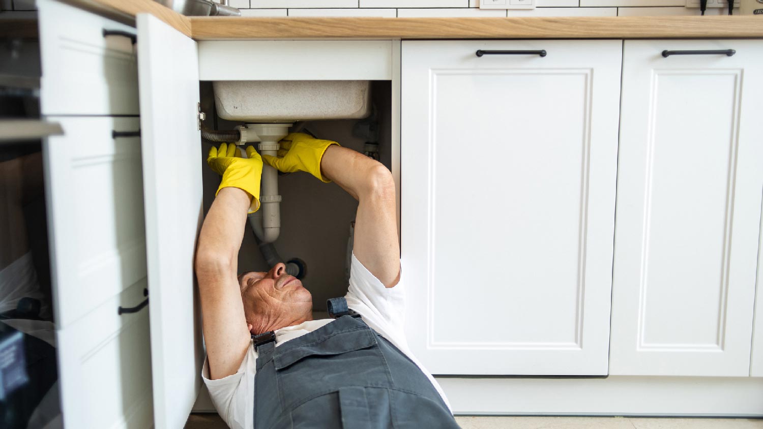 A plumber fixing a clogged drain line