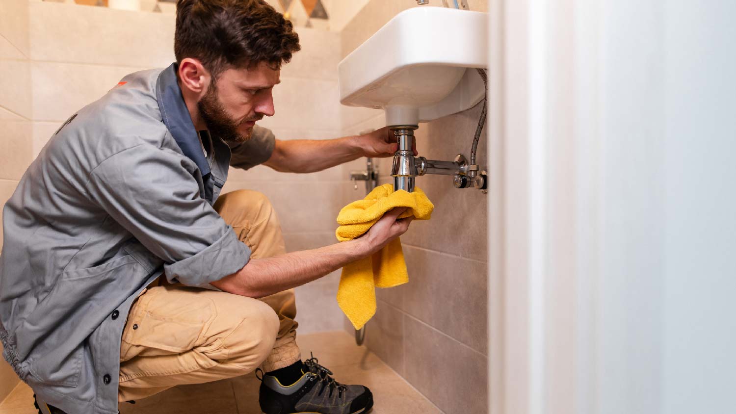 A plumber fixing a half bathroom’s sink