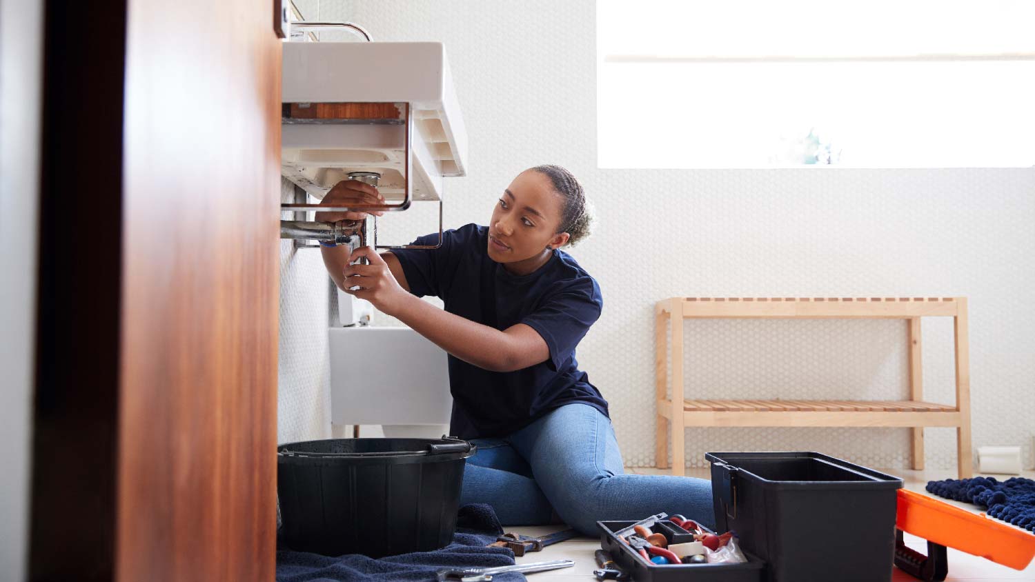 A plumber fixing a leaking faucet