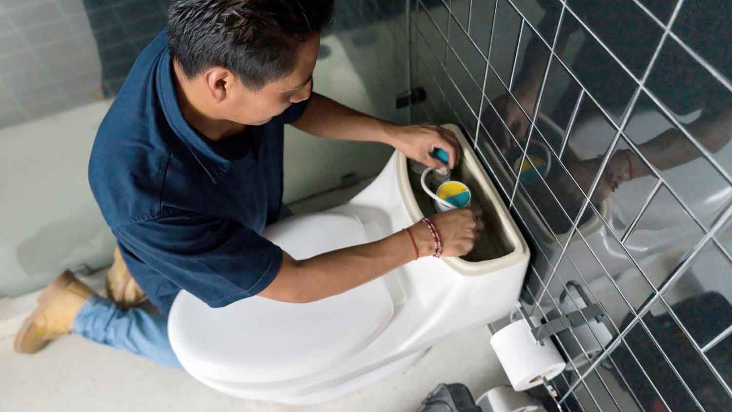 Plumber fixing a toilet leak