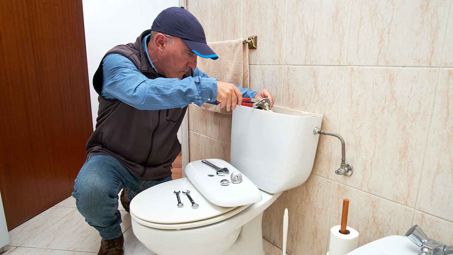 Plumber fixing toilet tank