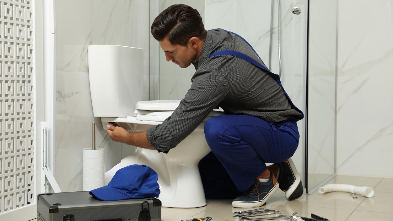 A plumber fixing a toilet flush