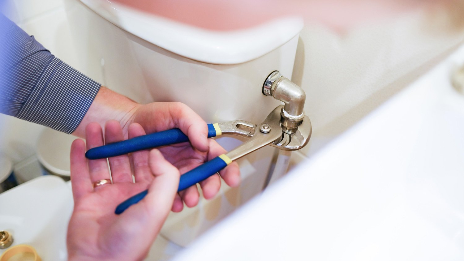 Close-up of a plumber fixing a toilet