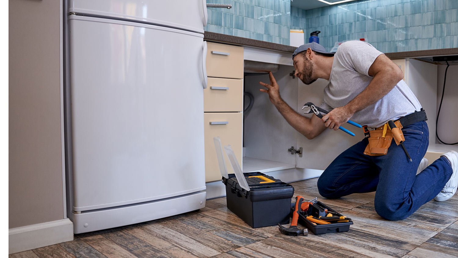 Plumber inspecting under kitchen sink