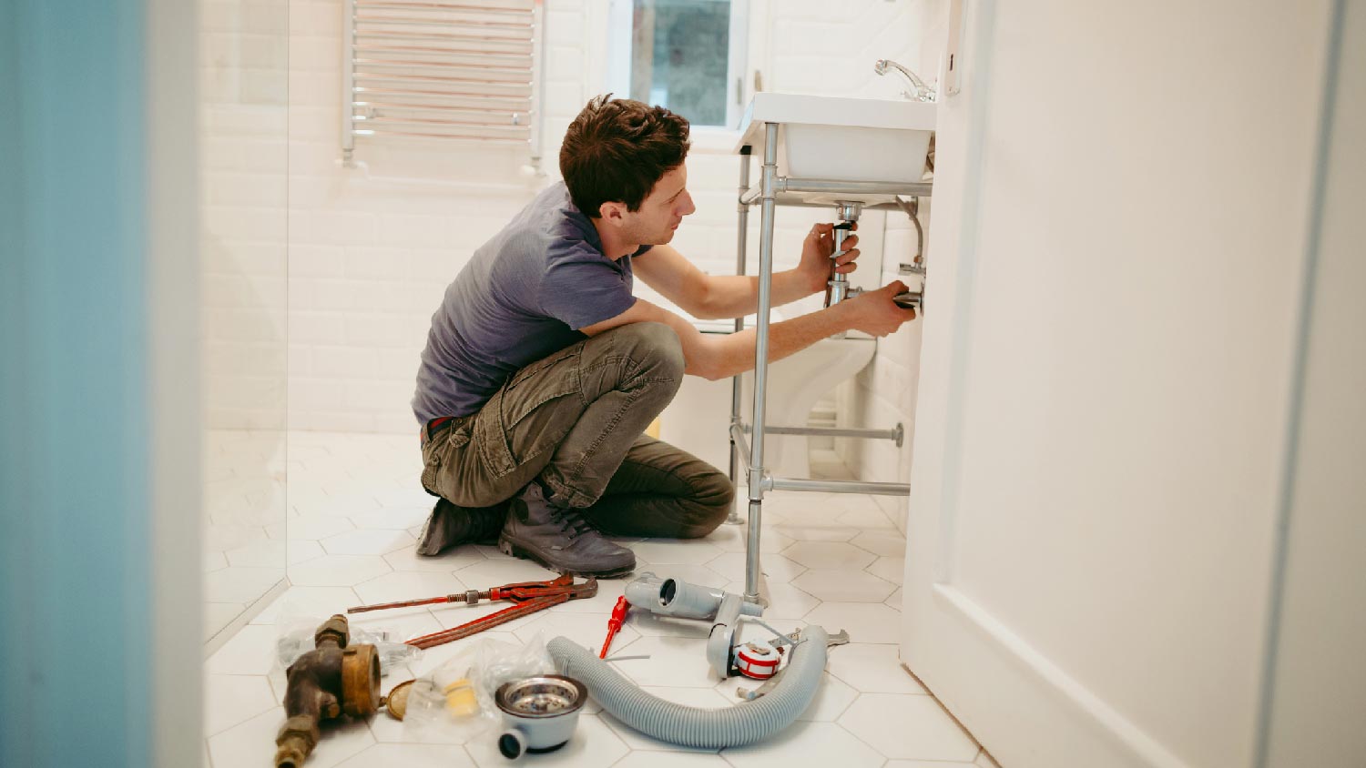 A plumber installing a bathroom sink