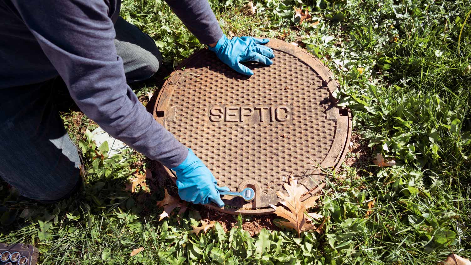 plumber opening septic system tank