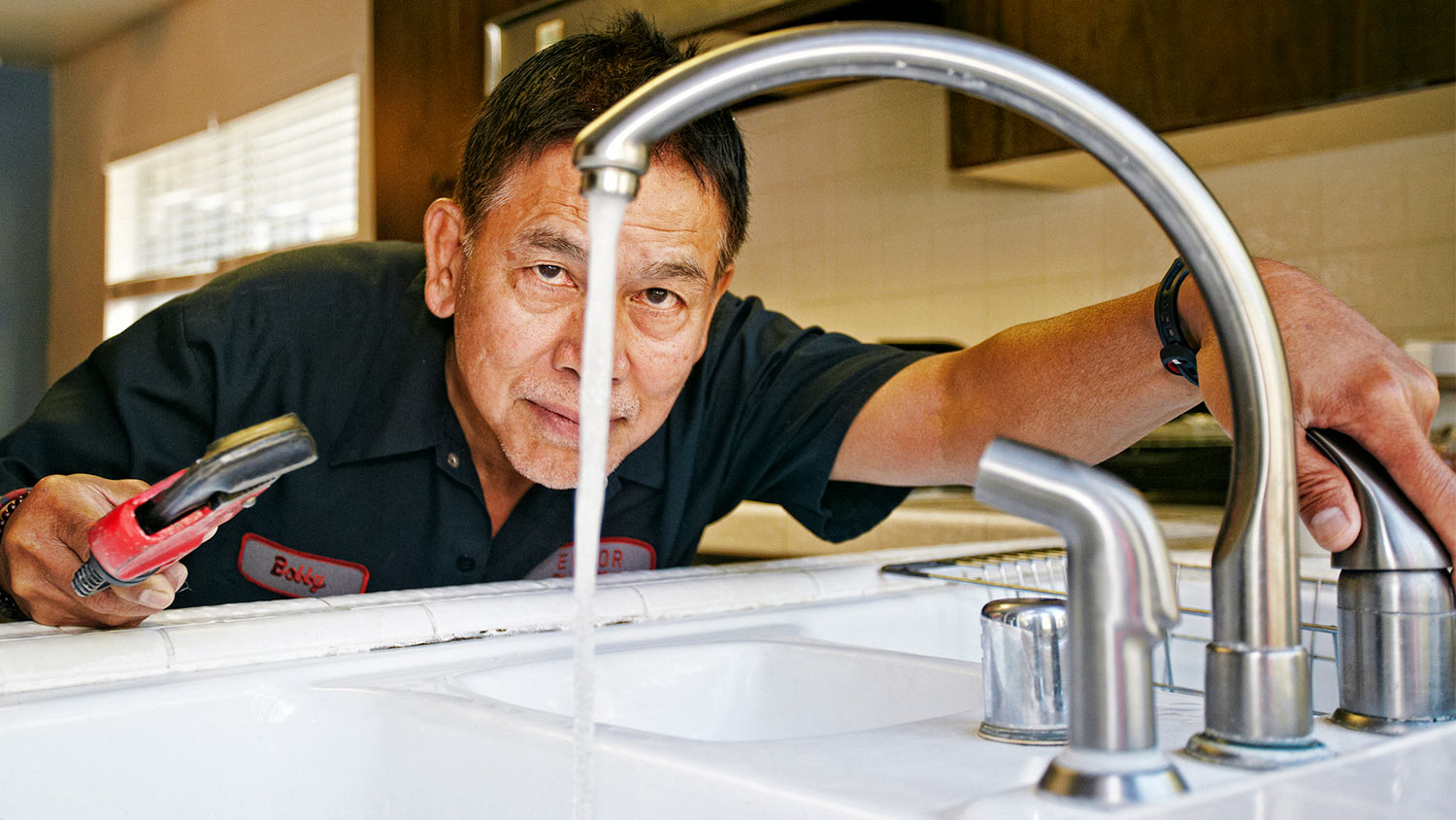 Plumber examining sink water flow