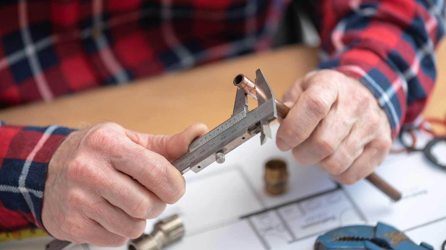 Plumber measuring a coper pipe with a caliper