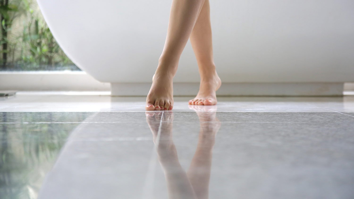 Barefoot female legs in bathroom