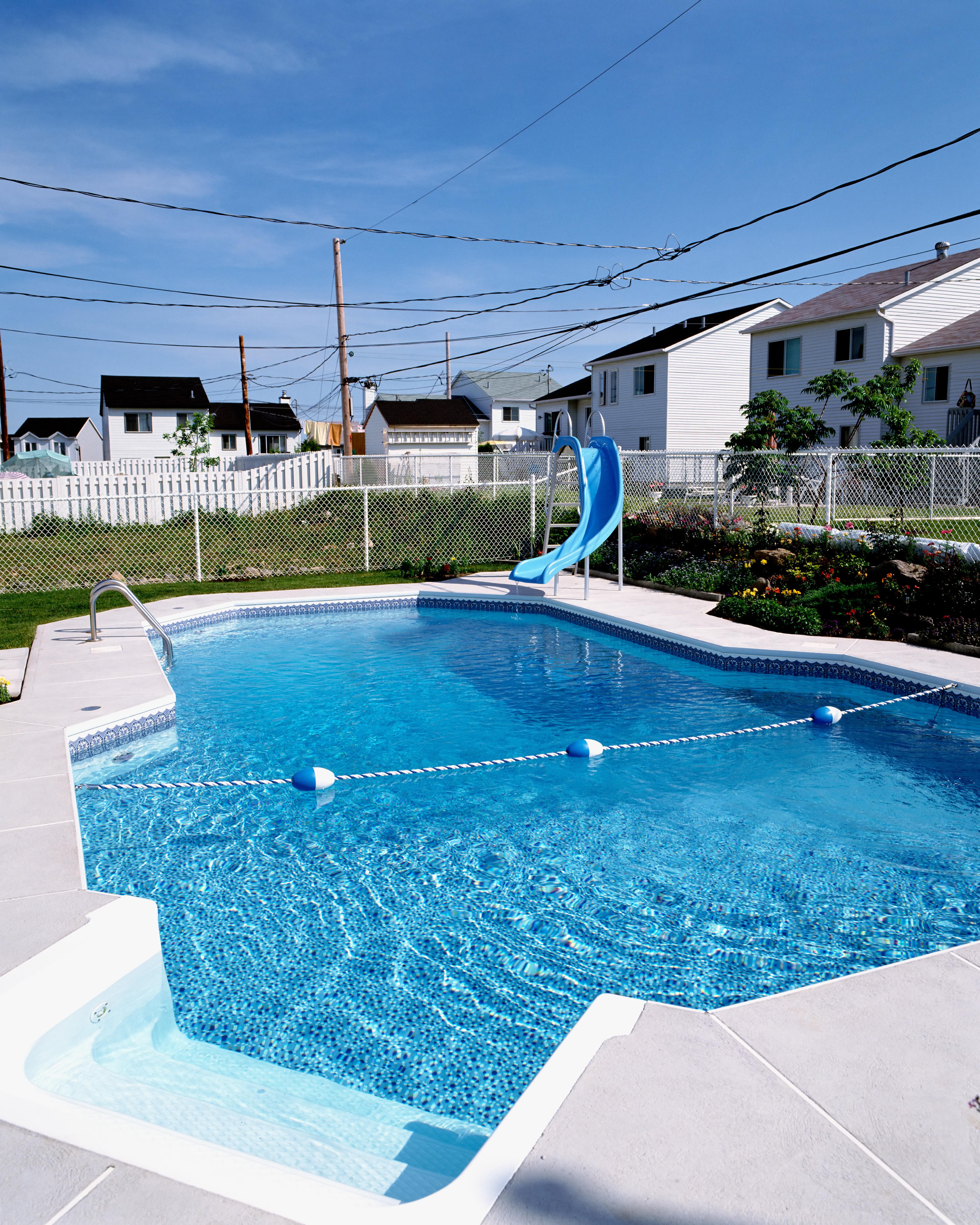 An inground pool surrounded by a chain-link fence